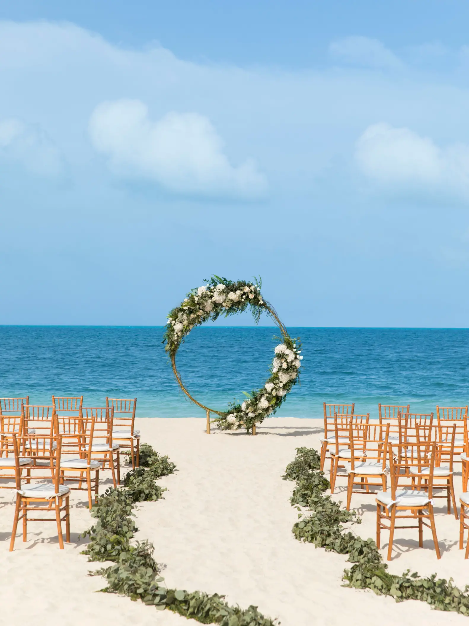 Circular floral arch for a beach wedding ceremony at Excellence Playa Mujeres, Cancun
