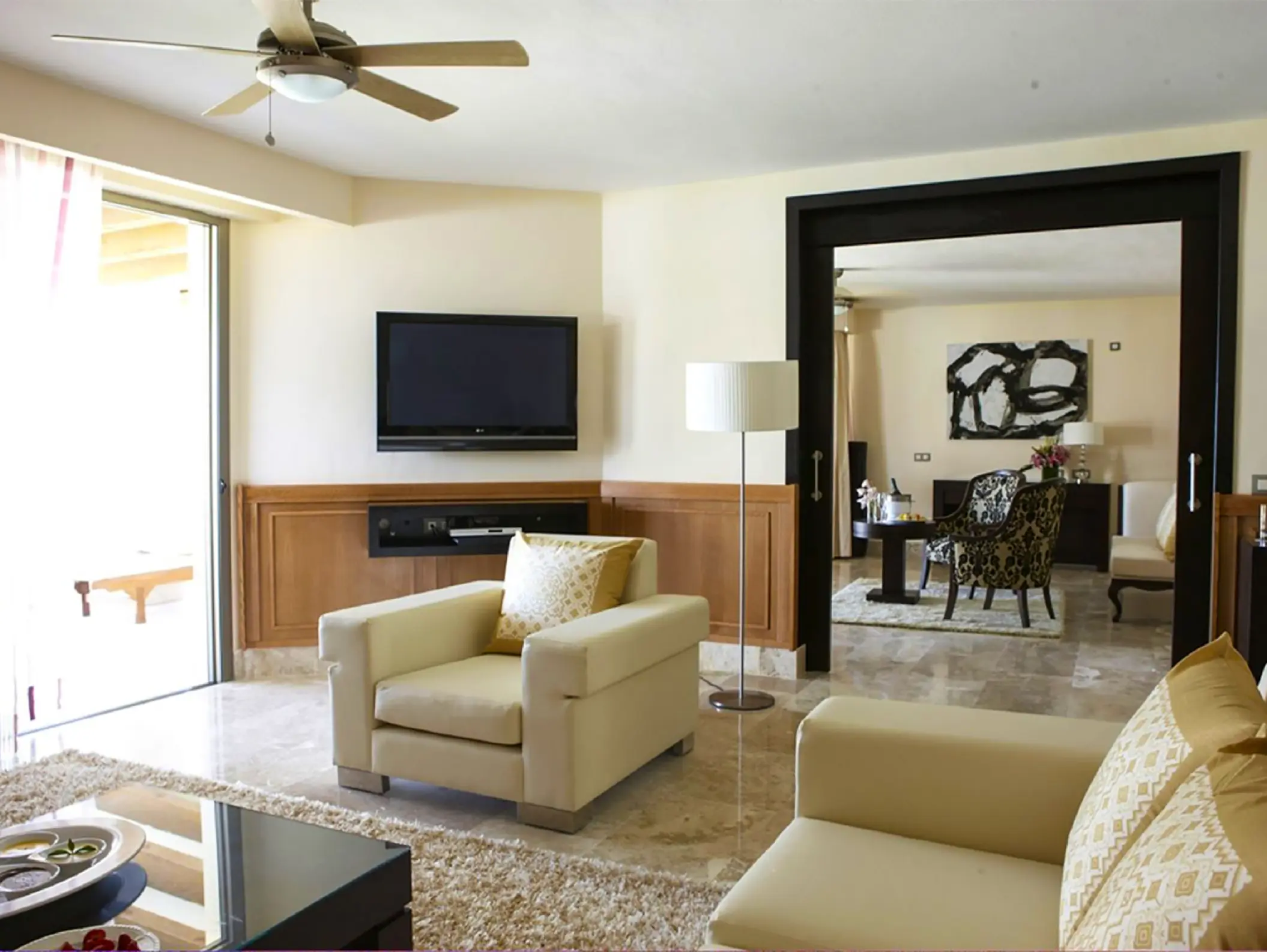 Honeymoon suite living area with cream armchairs and marble floors at Excellence Playa Mujeres, Cancun