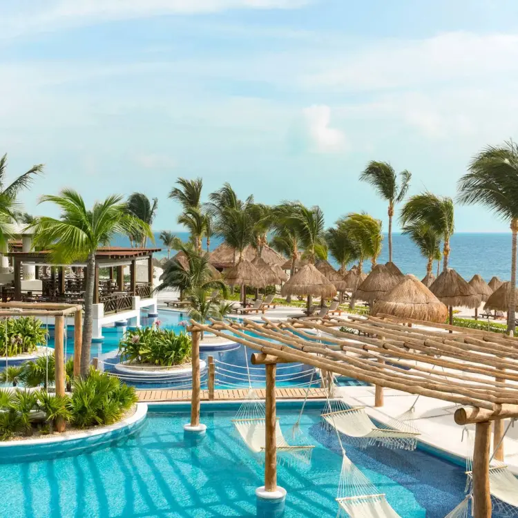 Overview of swimming pools and over-water hammocks at Excellence Playa Mujeres, Cancun