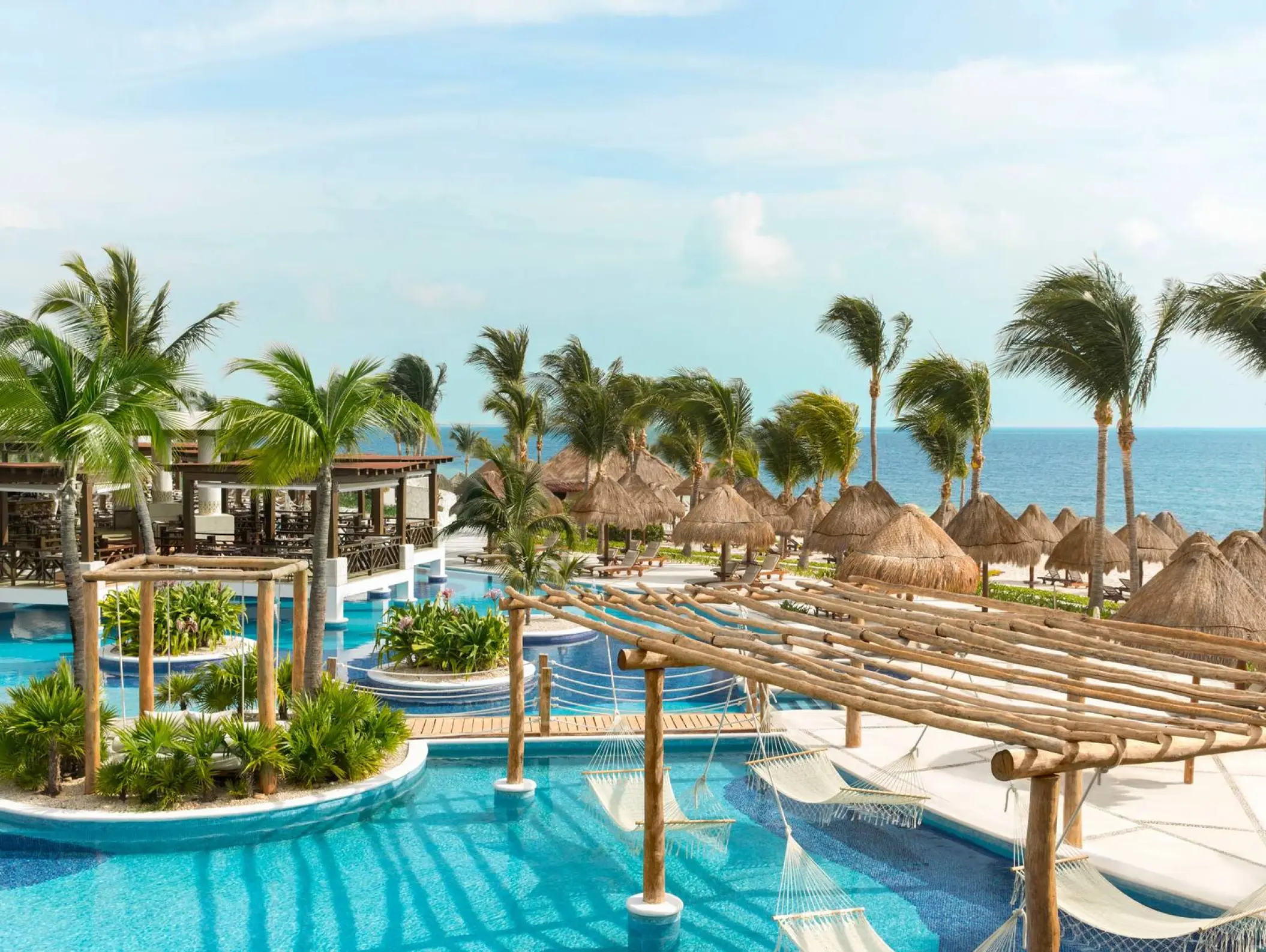 Overview of swimming pools and over-water hammocks at Excellence Playa Mujeres, Cancun