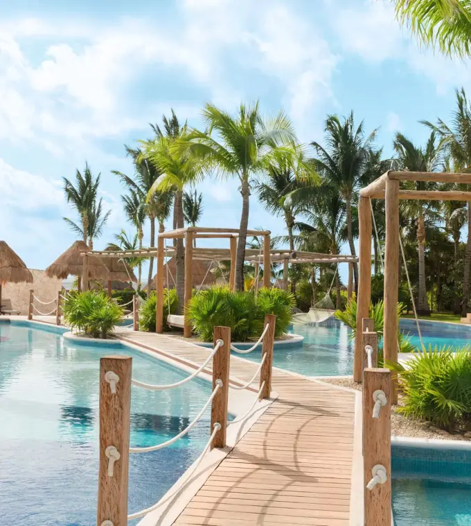 Excellence Playa Mujeres winding pool with wooden bridges and palm trees, Cancun