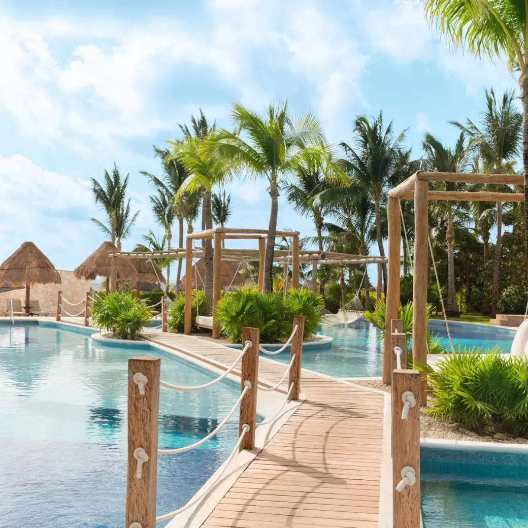 Excellence Playa Mujeres winding pool with wooden bridges and palm trees, Cancun
