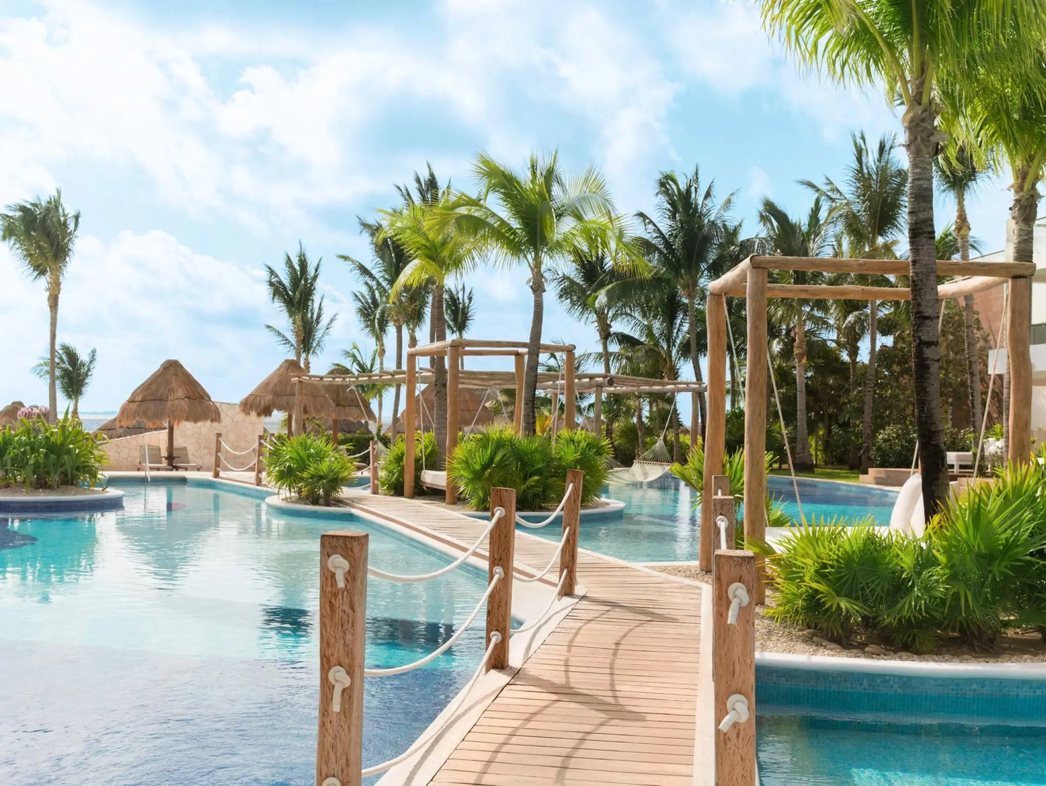 Excellence Playa Mujeres winding pool with wooden bridges and palm trees, Cancun