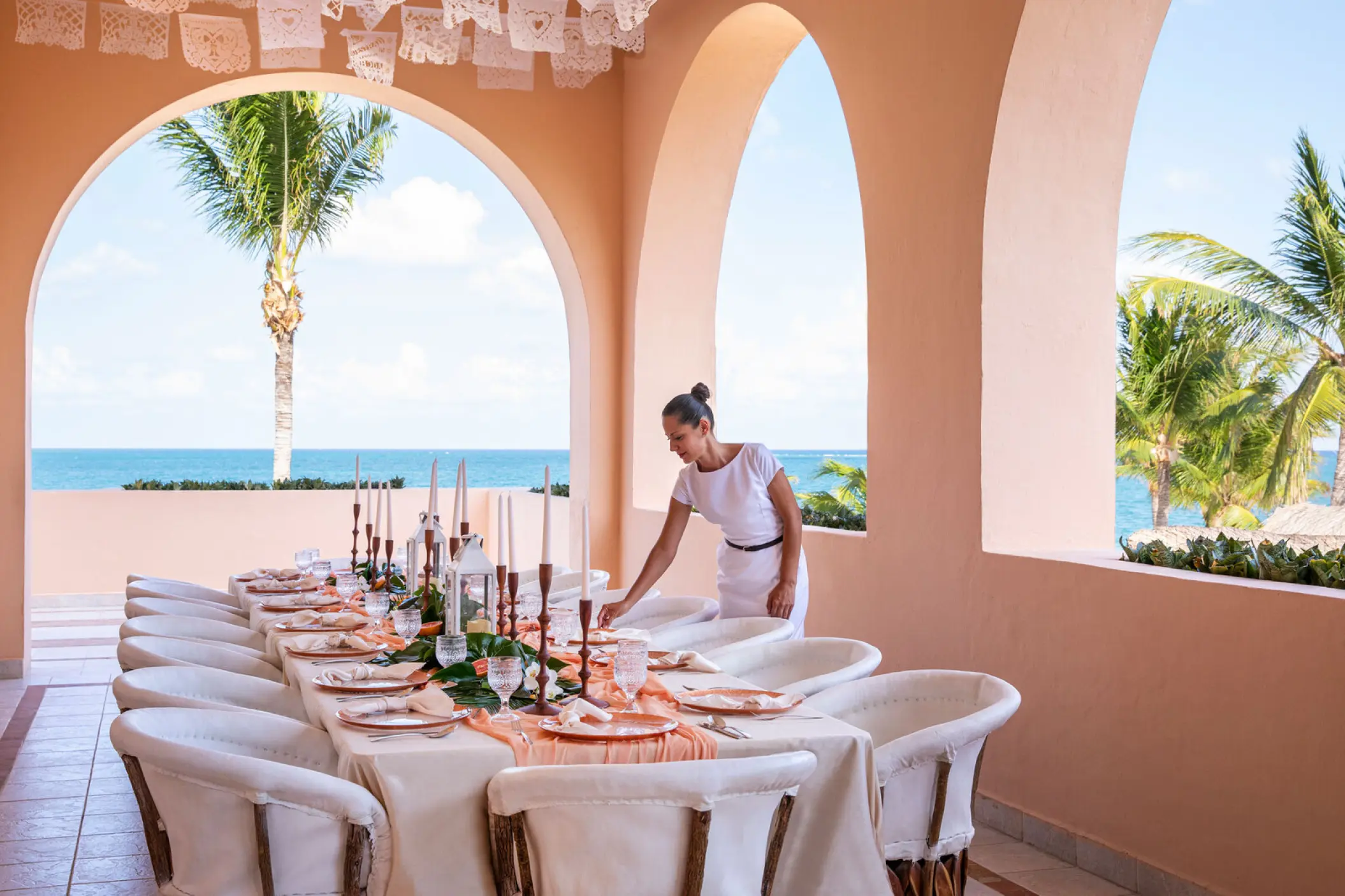Wedding reception table setup under arched terrace at Excellence Riviera Cancun, Riviera Maya