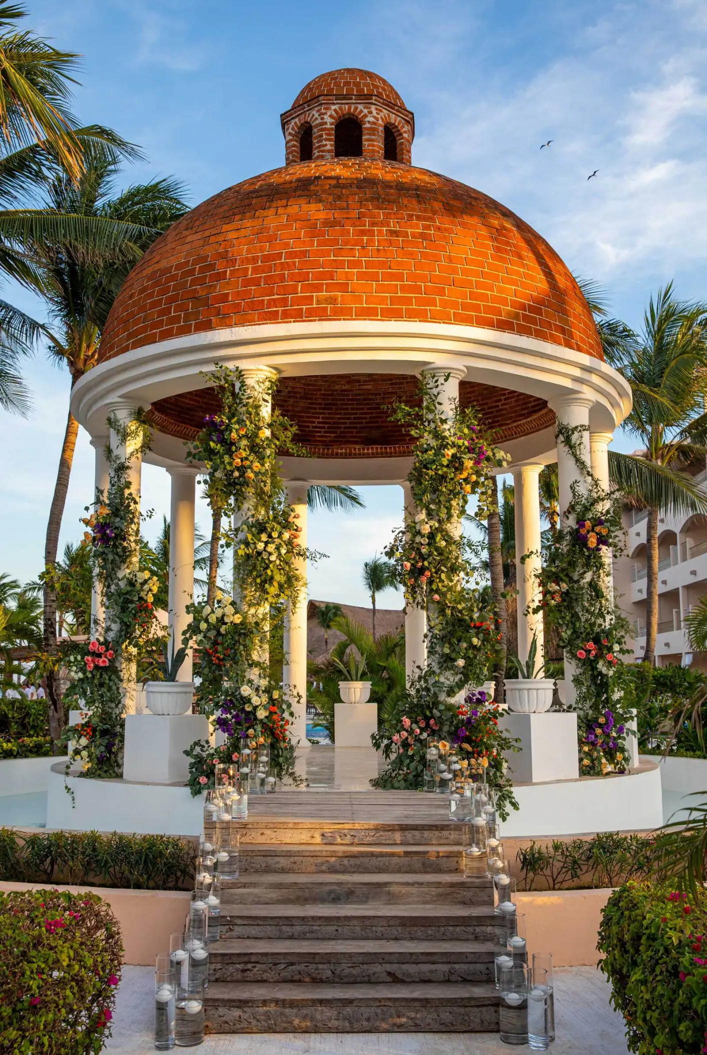 Stone wedding gazebo with floral arrangements and candles at Excellence Riviera Cancun, Riviera Maya
