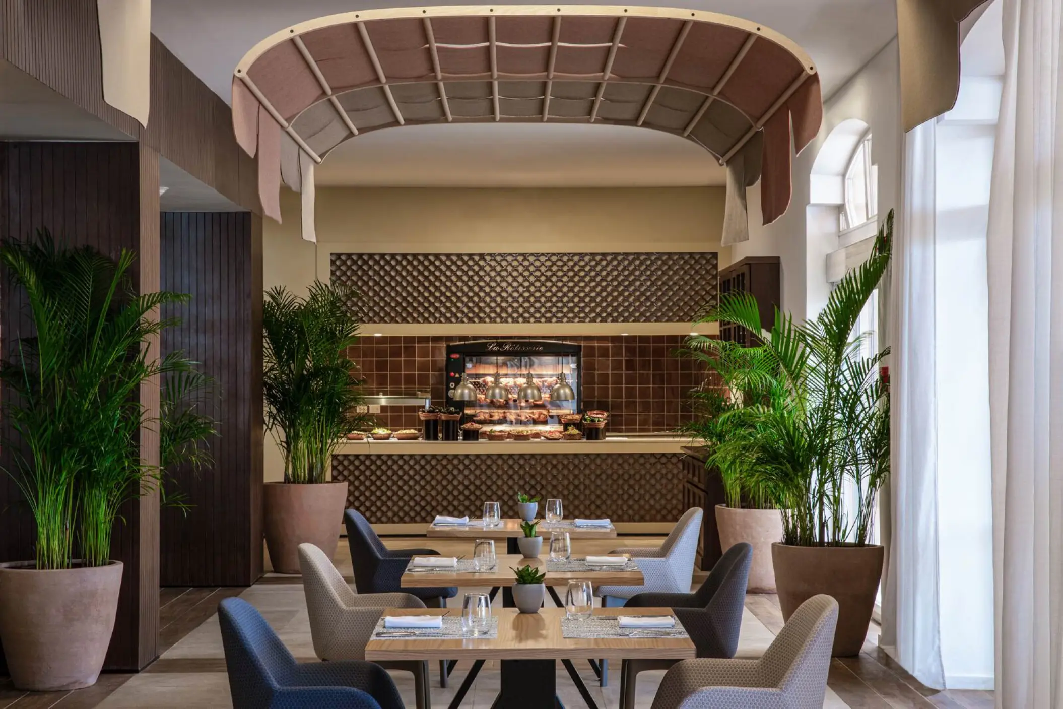 Modern restaurant dining room with potted palms at Excellence Riviera Cancun, Riviera Maya