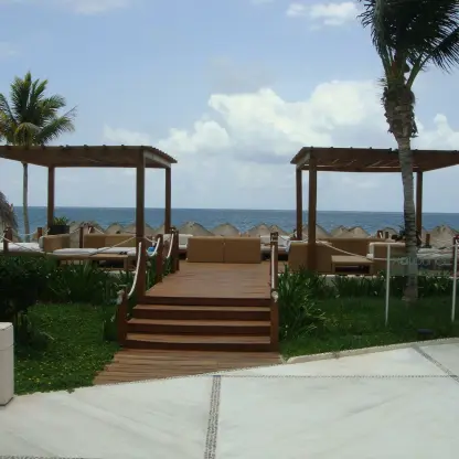 Outdoor lounge with wooden gazebos and ocean views at Excellence Riviera Cancun, Riviera Maya