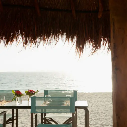Dunas Beach House dining table under a palapa at Finest Playa Mujeres, Cancun
