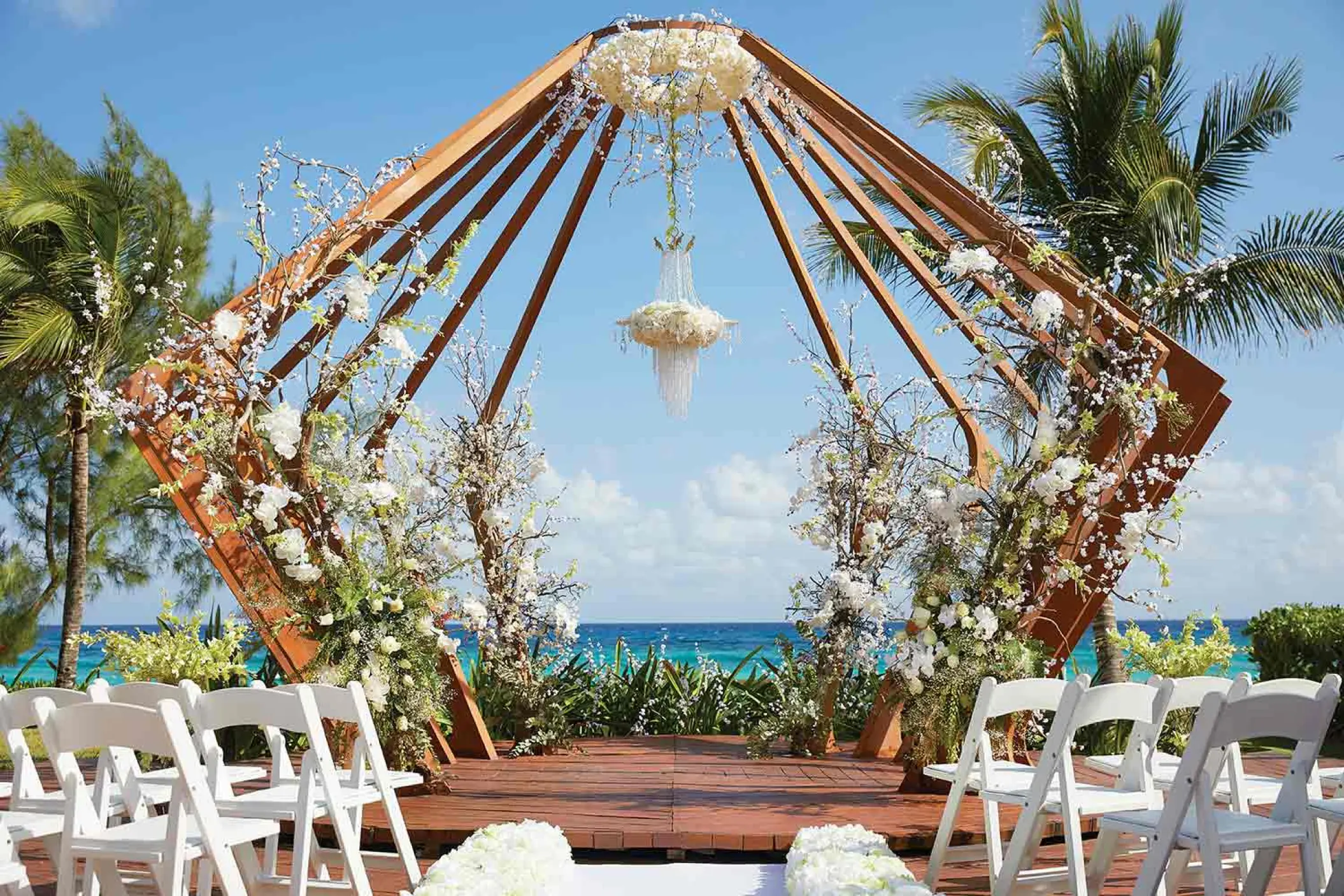 Geometric wooden gazebo wedding ceremony with white flowers at The Fives Beach, Playa Del Carmen
