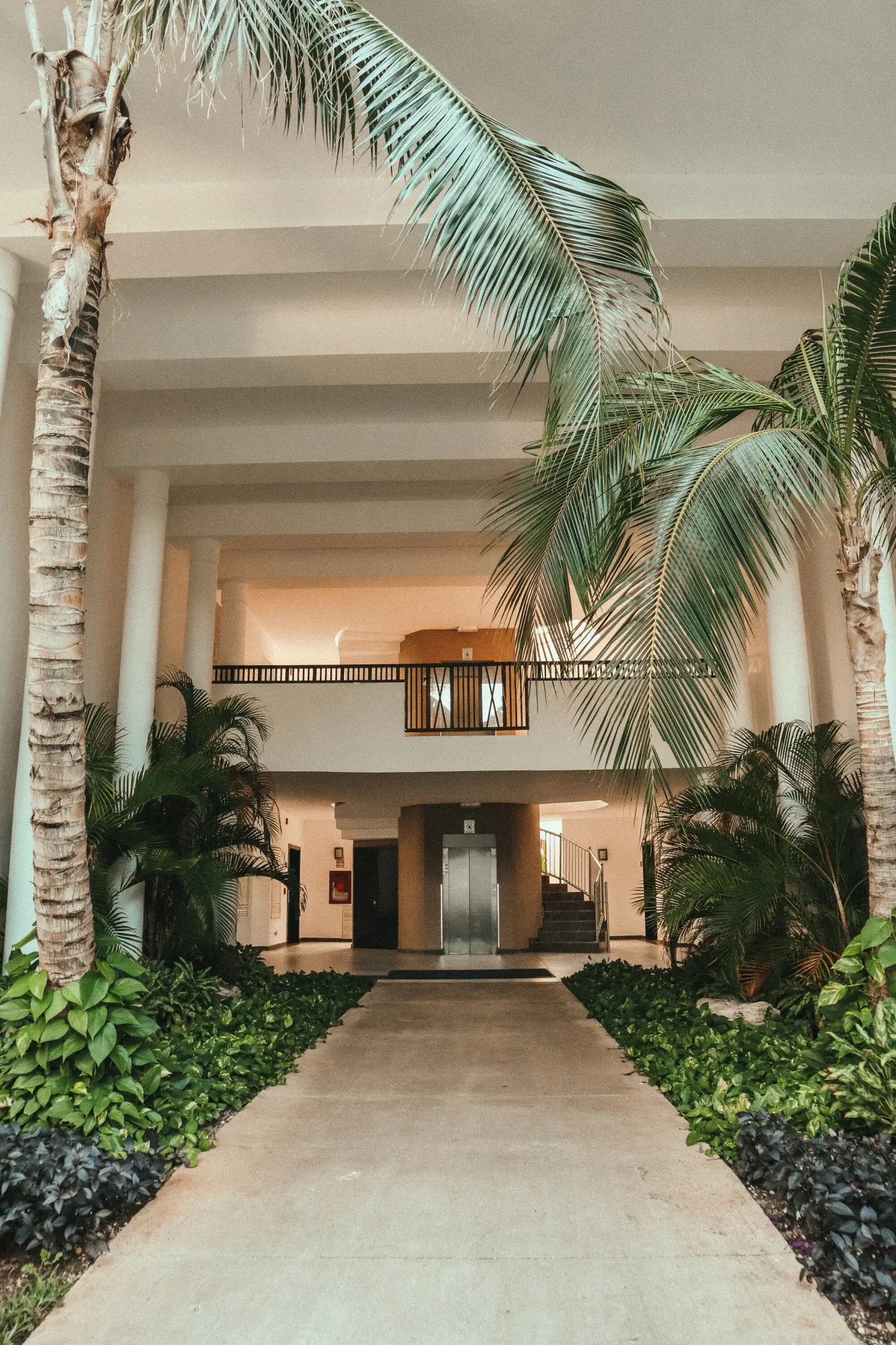 Modern open-air lobby and palm trees at The Fives Beach Hotel, Playa Del Carmen
