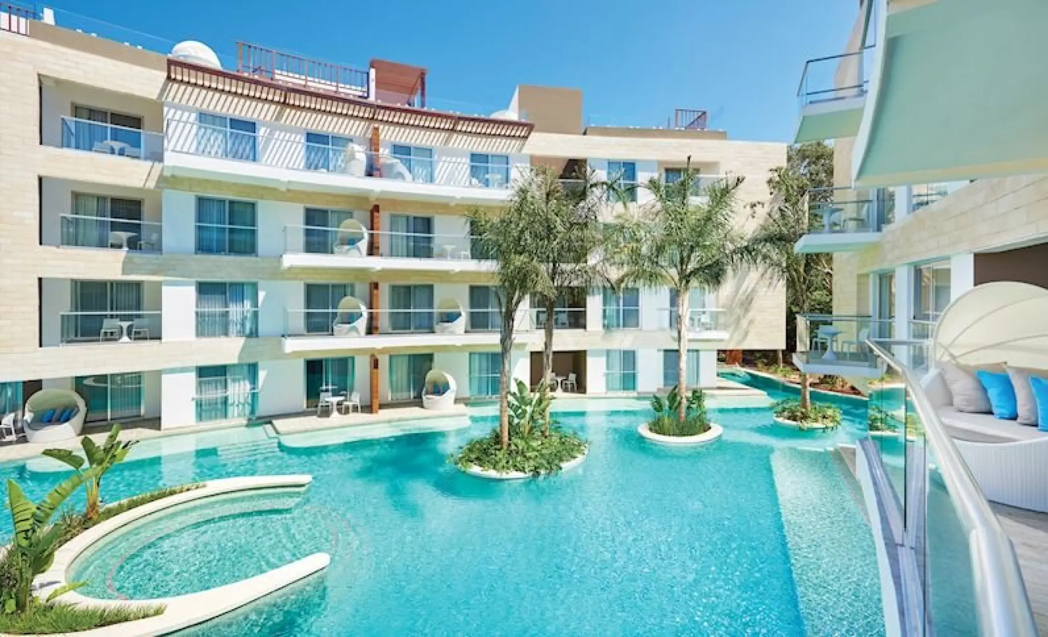Modern guest buildings and swim-up pools at The Fives Beach Hotel, Playa Del Carmen