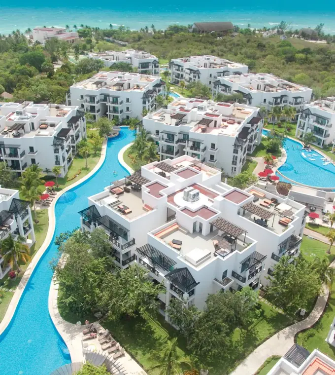 Aerial view of pools and white modern buildings at The Fives Beach Hotel, Playa Del Carmen