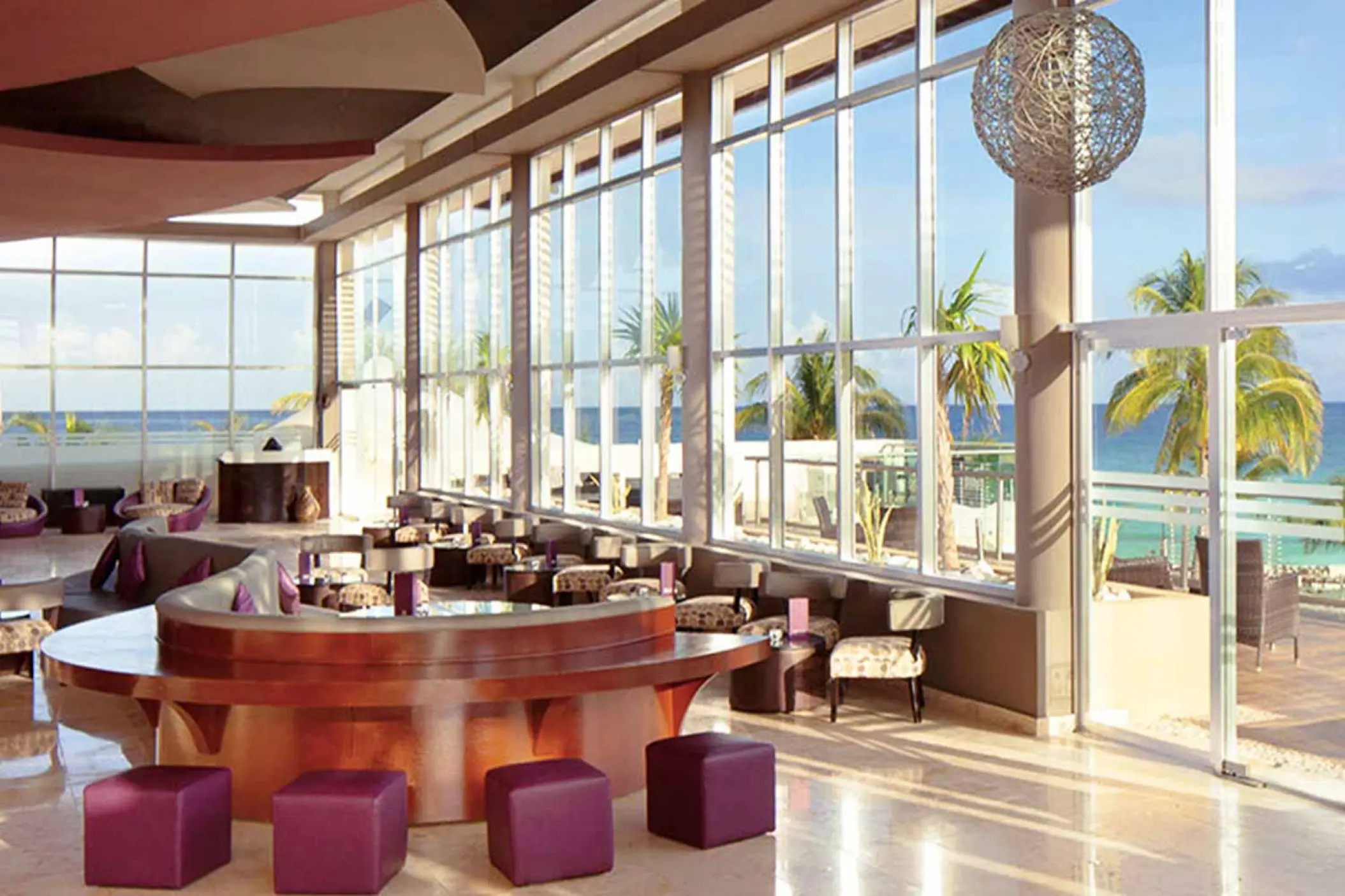 Zky Bar lounge with floor-to-ceiling windows and ocean views at The Fives Beach, Playa Del Carmen