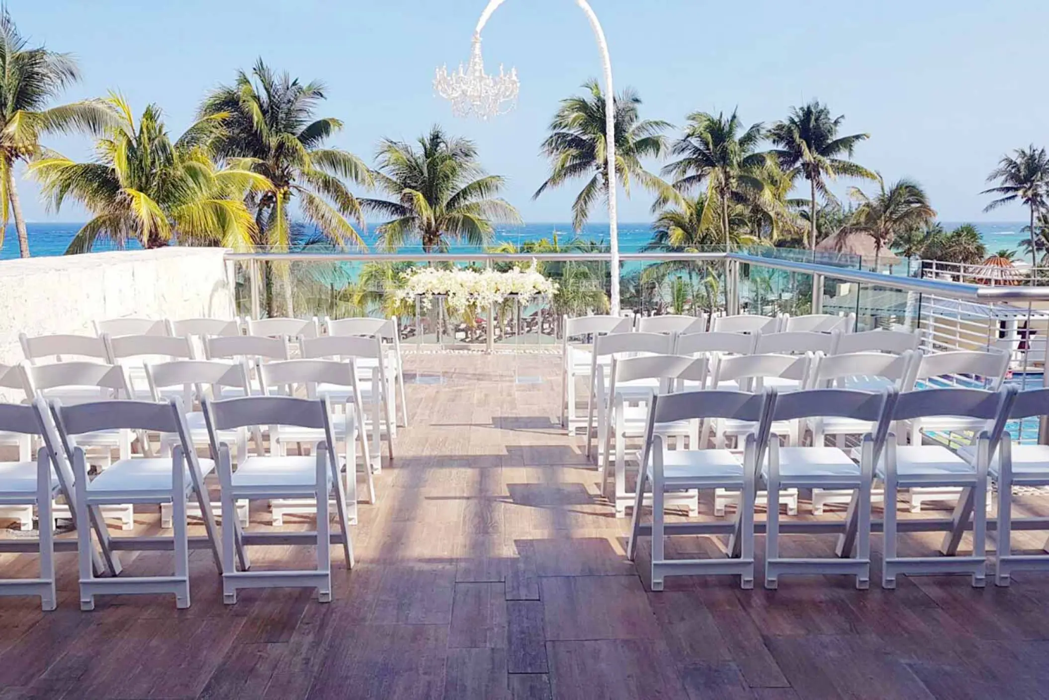 Rooftop terrace wedding ceremony setup with white chairs and ocean views at The Fives Beach Hotel, Playa Del Carmen