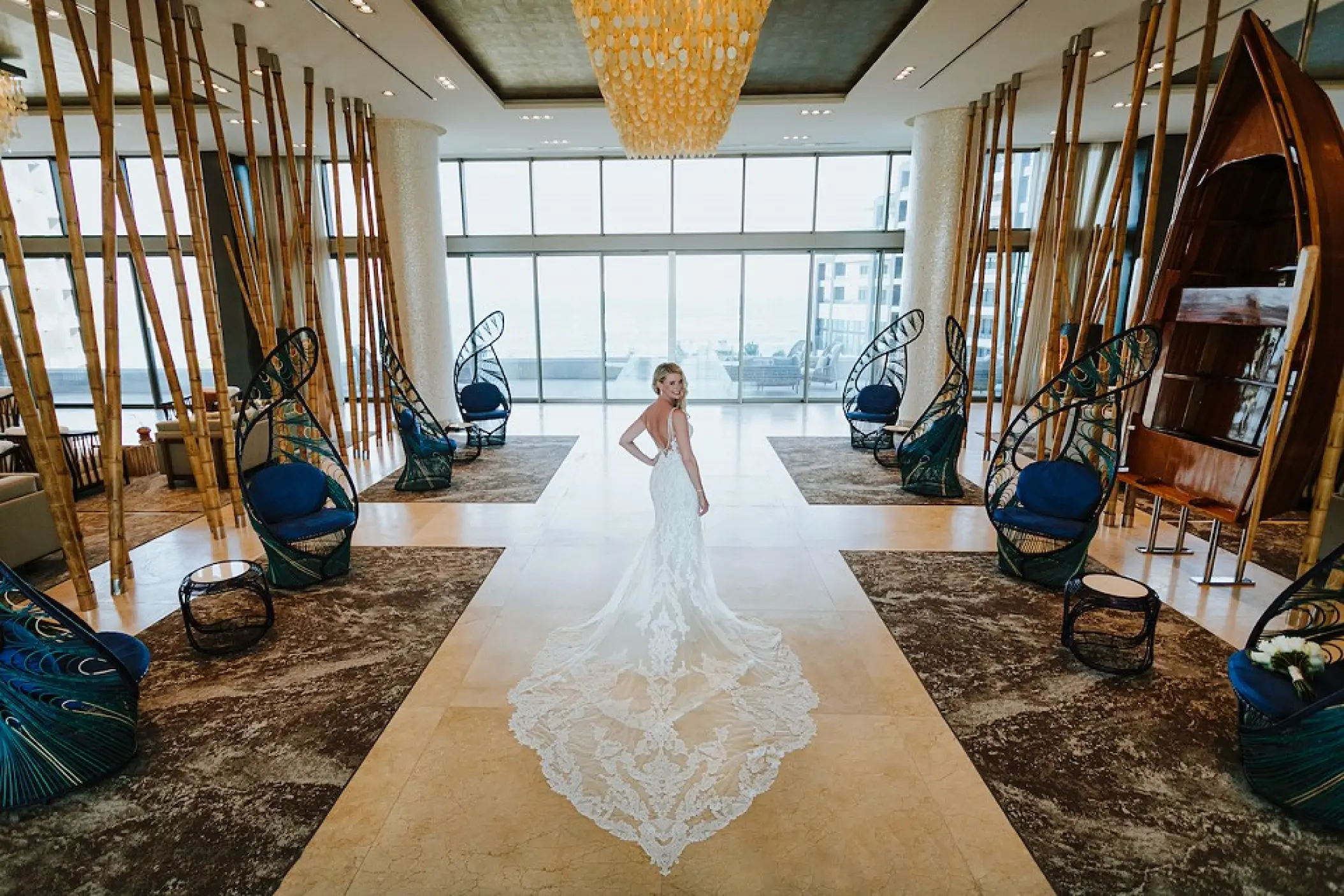 Bride in a long lace train standing in the modern lobby at Garza Blanca Los Cabos, Cabo San Lucas