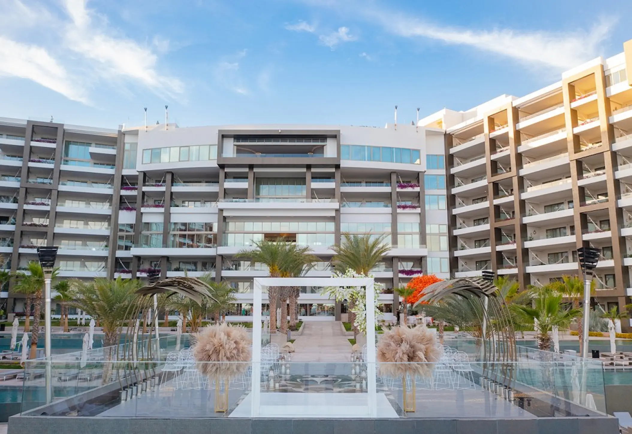 Modern wedding ceremony setup on a terrace with white arch at Garza Blanca Los Cabos, Cabo San Lucas