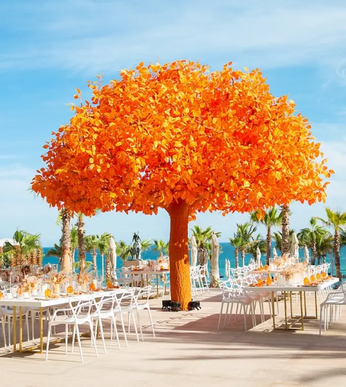 Outdoor wedding reception with a large orange tree sculpture at Garza Blanca Los Cabos, Cabo San Lucas