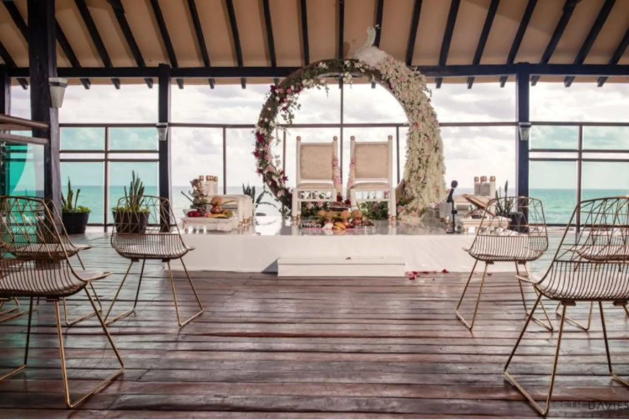 Oceanfront pier wedding ceremony with floral moon gate arch at Generations Riviera Maya