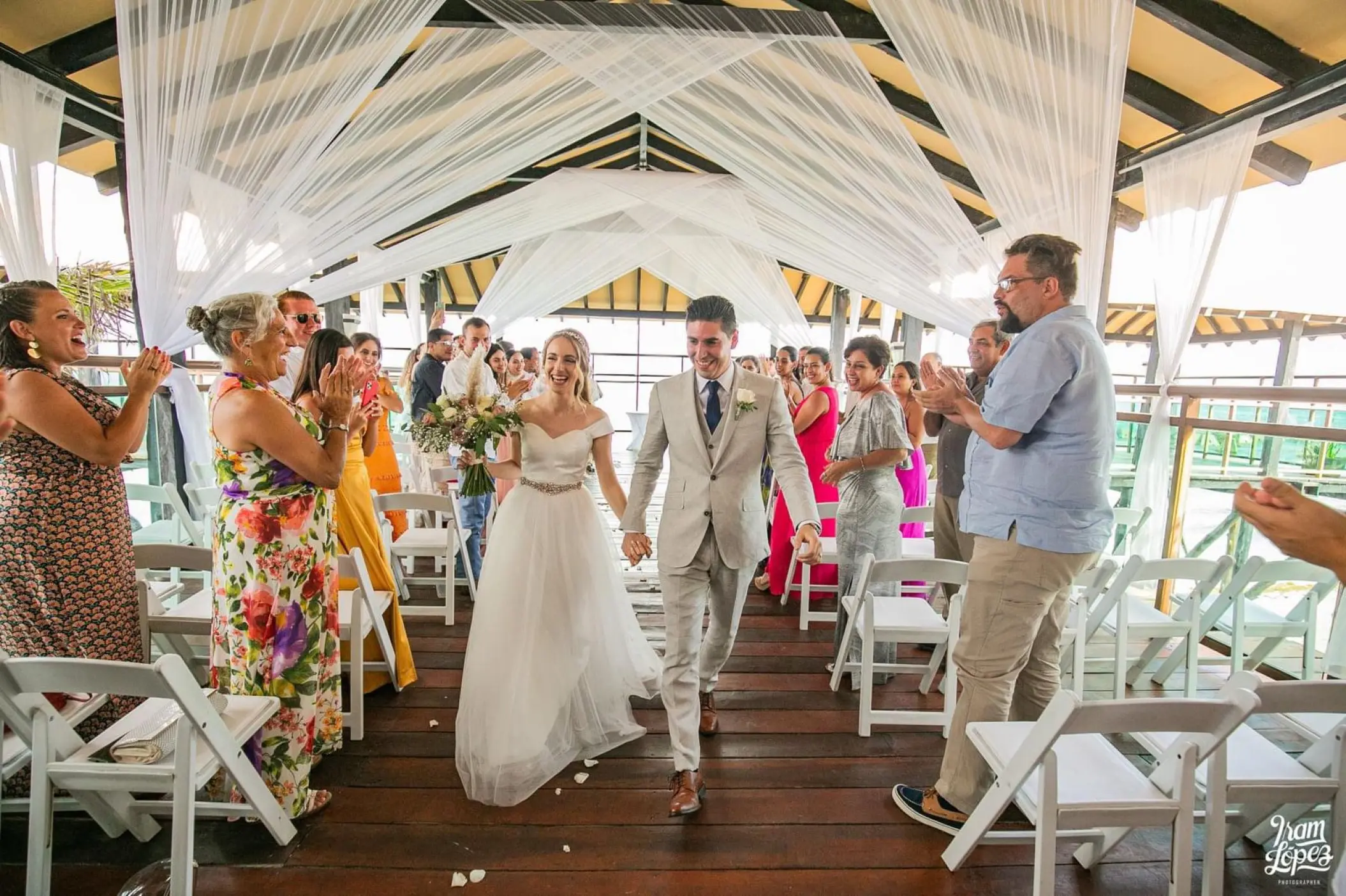 Bride and groom walking down the aisle at a pier deck wedding ceremony at Generations Riviera Maya