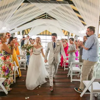 Bride and groom walking down the aisle at a pier deck wedding ceremony at Generations Riviera Maya