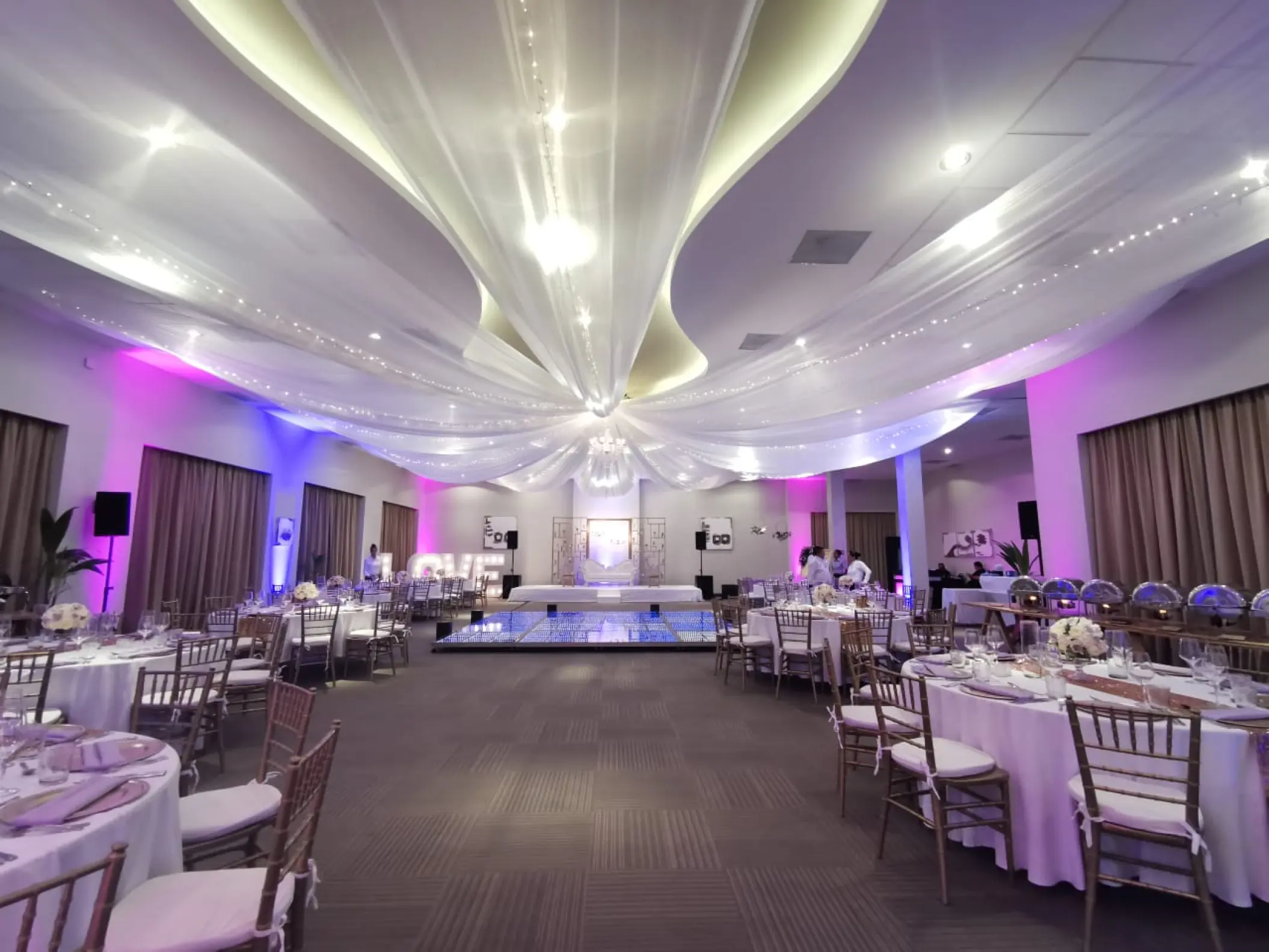 Ballroom wedding reception with fabric ceiling drapes and purple lighting at Generations Riviera Maya, Riviera Maya
