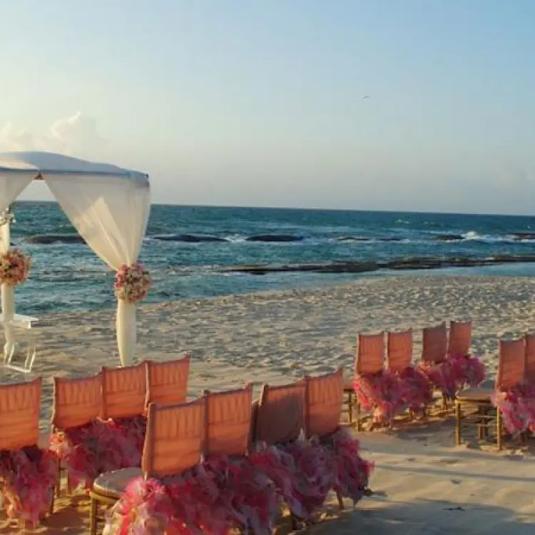 Beachfront wedding ceremony with a white canopy and pink floral decor at Generations Riviera Maya, Riviera Maya