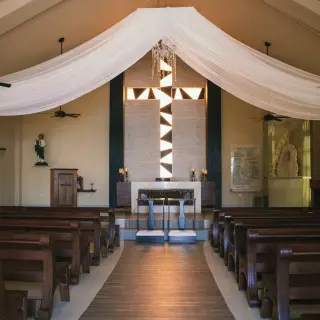 Chapel wedding ceremony venue with wooden pews and white draping at Generations Riviera Maya, Riviera Maya