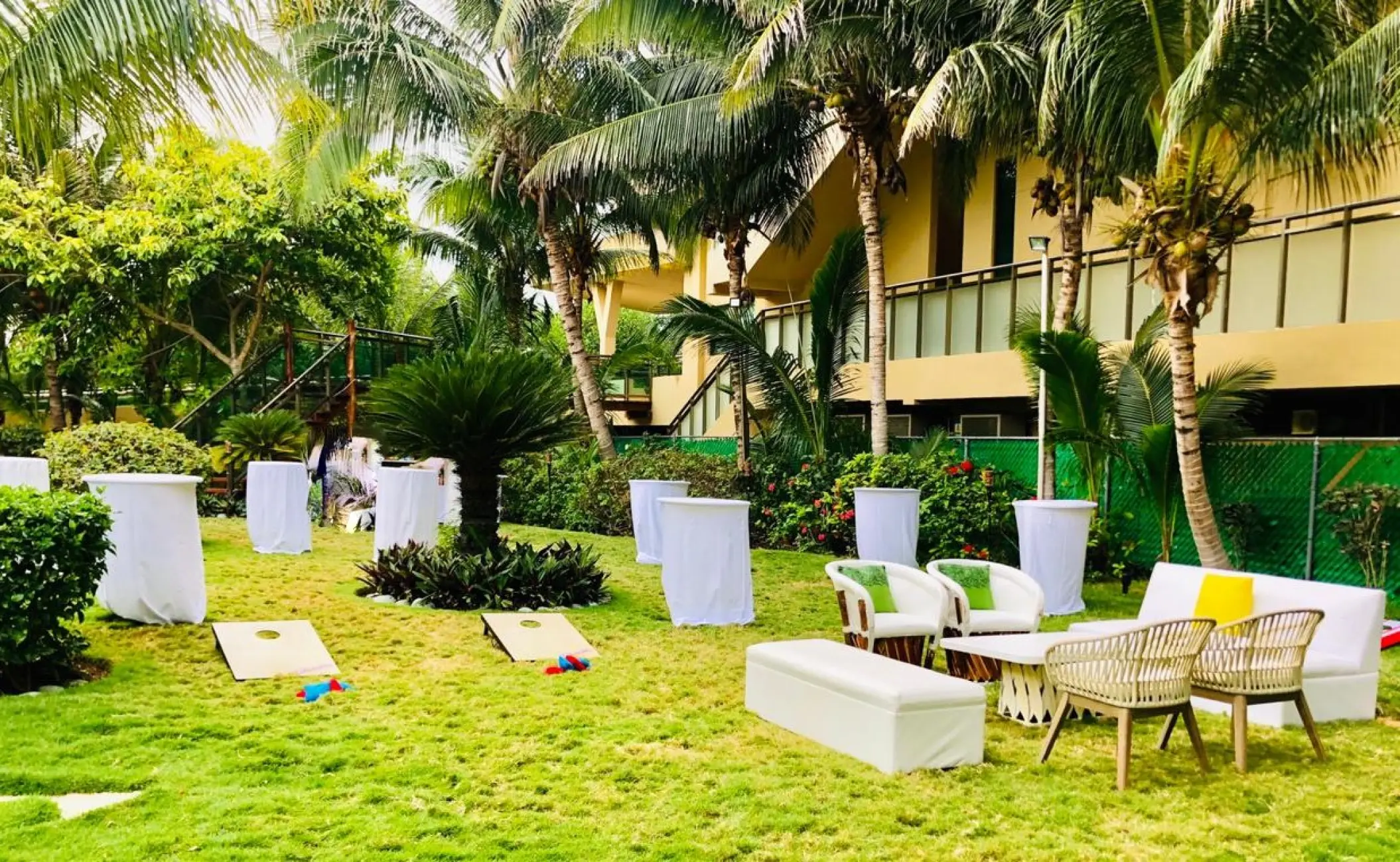 Garden wedding reception lounge with cocktail tables and lawn games at Generations Riviera Maya