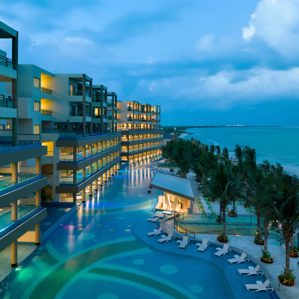 Generations Riviera Maya oceanfront suites and lit swimming pools at dusk, Riviera Maya