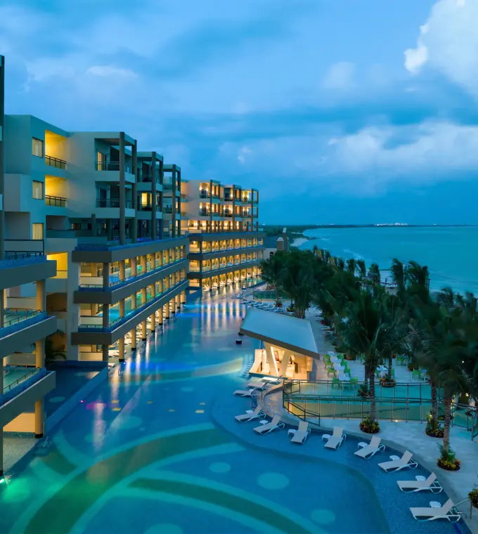 Generations Riviera Maya oceanfront suites and lit swimming pools at dusk, Riviera Maya