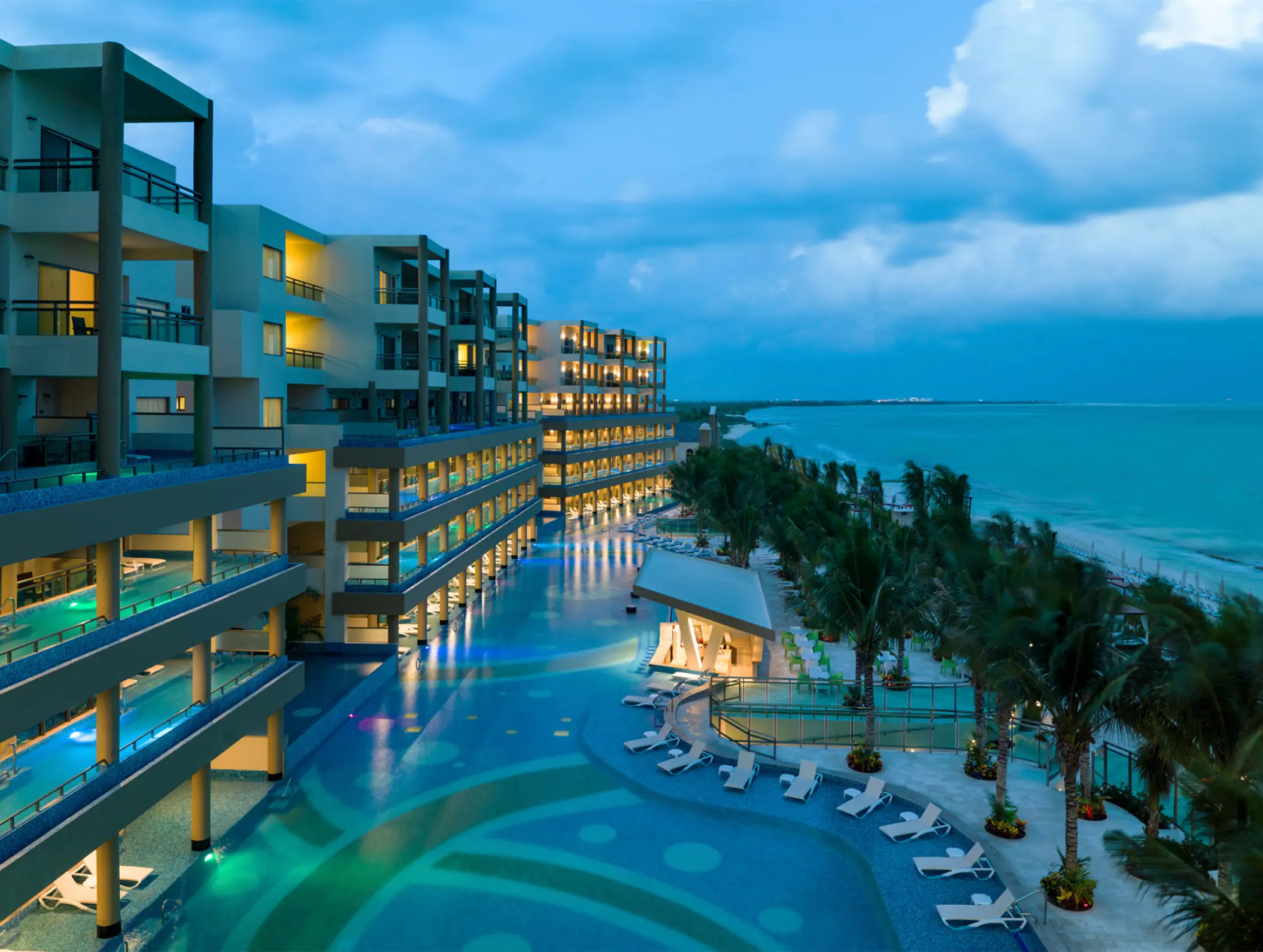 Generations Riviera Maya oceanfront suites and lit swimming pools at dusk, Riviera Maya