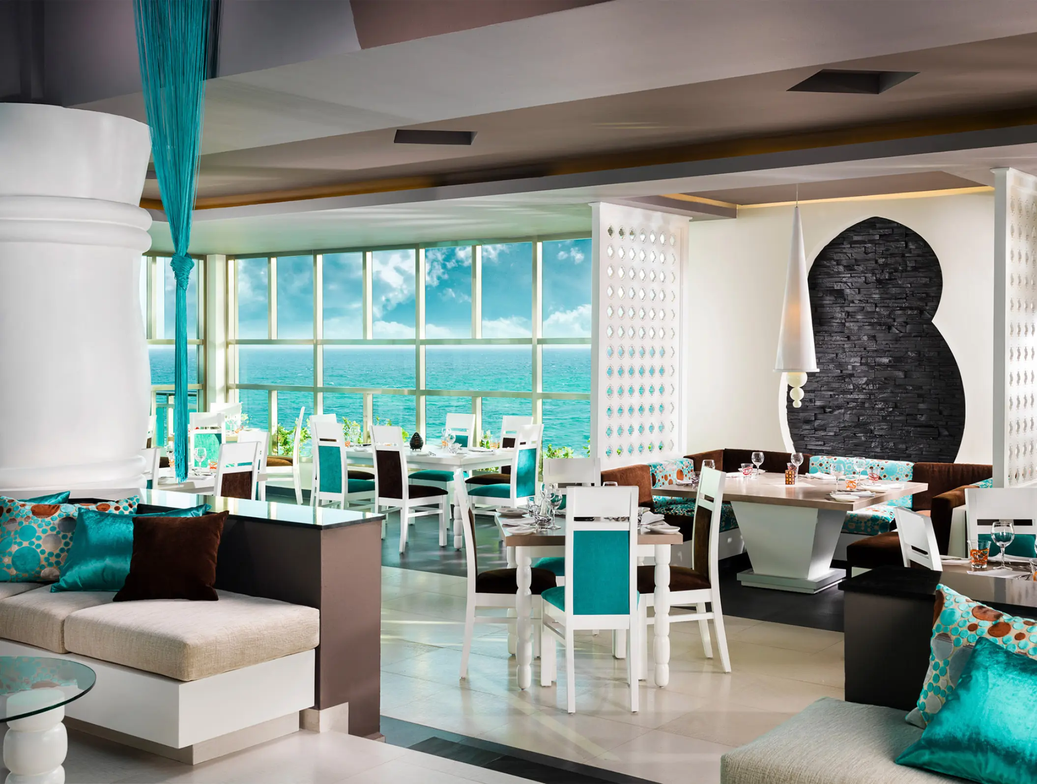 Modern oceanfront restaurant with white and turquoise seating at Generations Riviera Maya, Riviera Maya