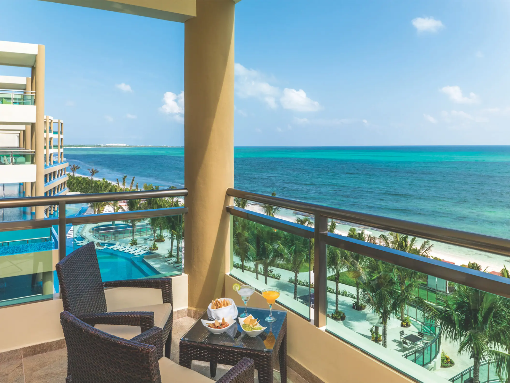 Generations Riviera Maya ocean view terrace with wicker chairs and drinks overlooking the Caribbean Sea