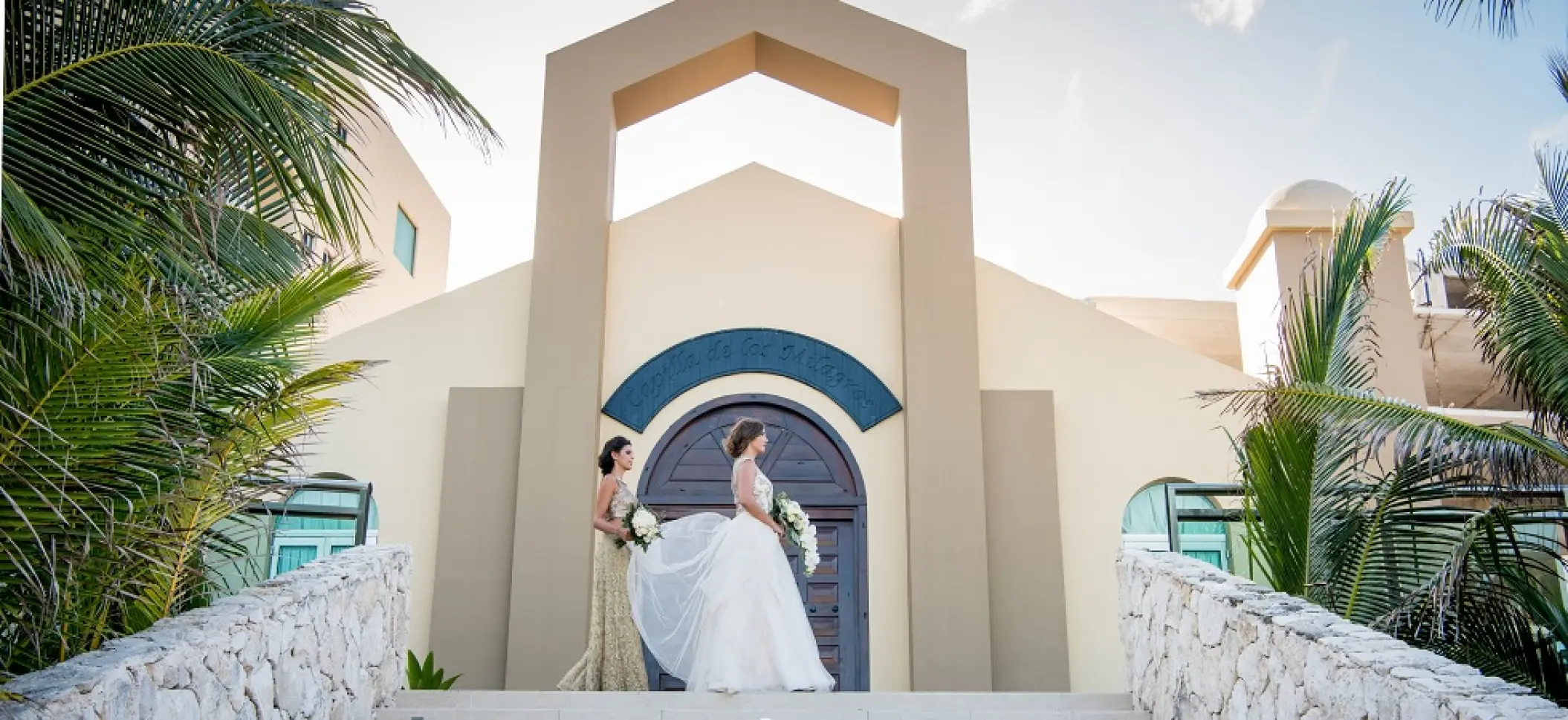 Bride and bridesmaid standing in front of the chapel at Generations Riviera Maya