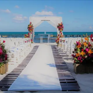 Beachfront wedding ceremony with white gazebo and colorful flowers at Generations Riviera Maya