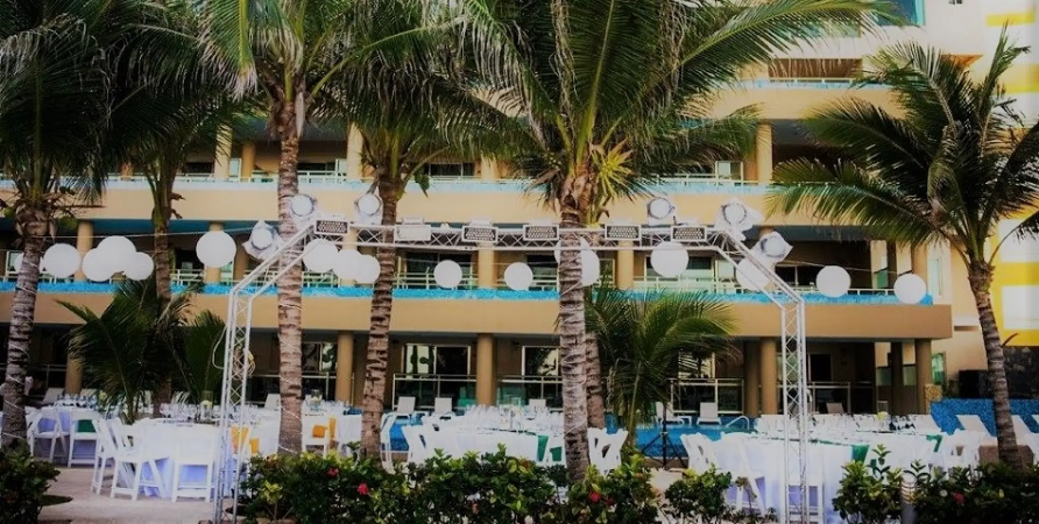 Outdoor wedding reception setup with white tables and paper lanterns at Generations Riviera Maya