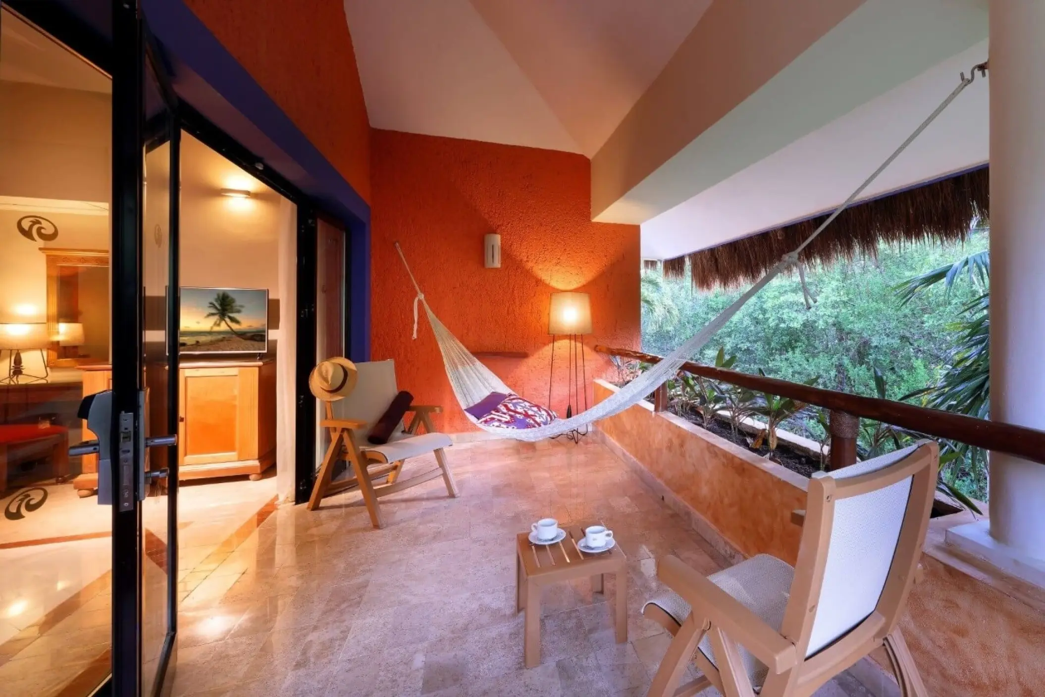 Romantic suite balcony with a white hammock and sitting area at Grand Palladium Colonial, Riviera Maya