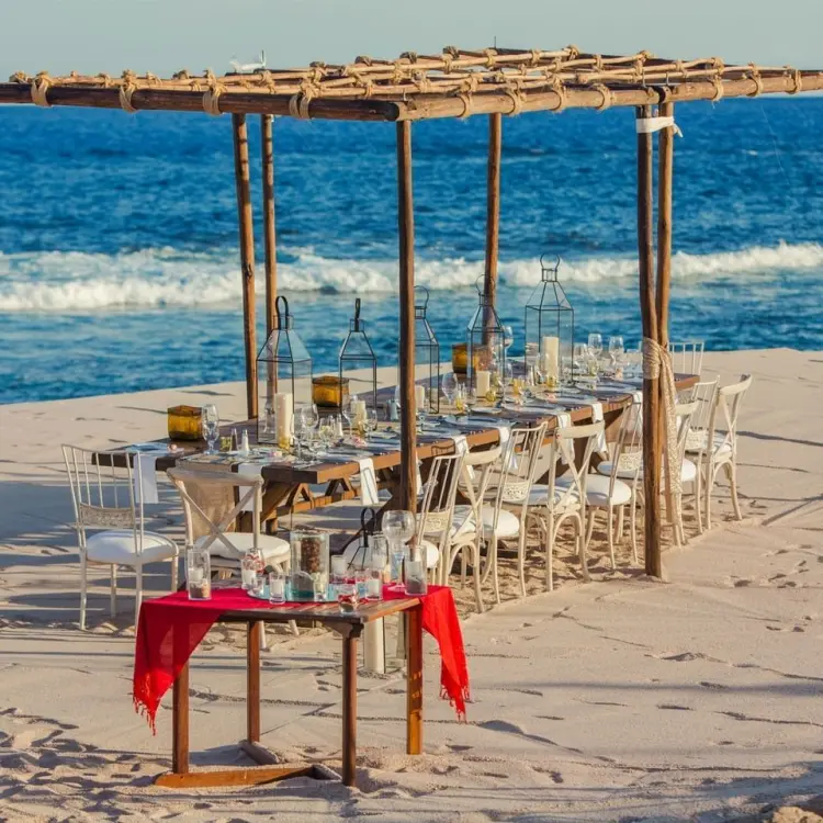 Beachfront wedding reception setup under a wooden pergola at Grand Fiesta Americana, Cabo San Lucas