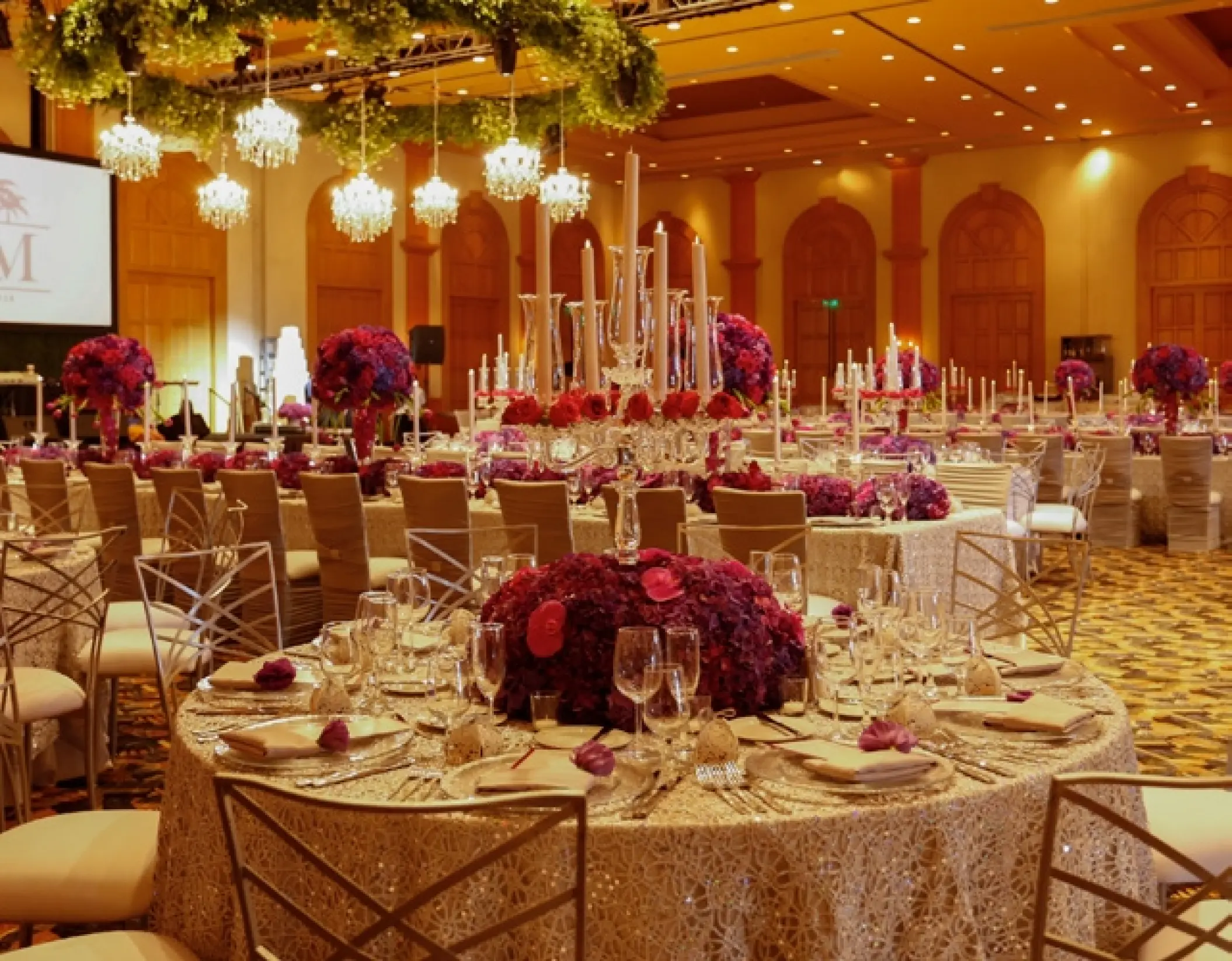 Ballroom wedding reception with floral centerpieces and hanging chandeliers at Grand Fiesta Americana Los Cabos