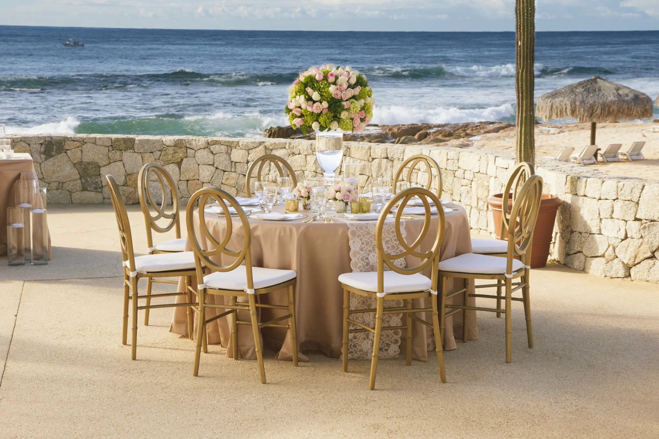 Outdoor wedding reception table with gold chairs overlooking the ocean at Grand Fiesta Americana, Cabo San Lucas