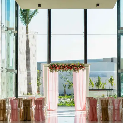 Indoor wedding ceremony with a pink draped huppah at Grand Palladium Costa Mujeres, Cancun