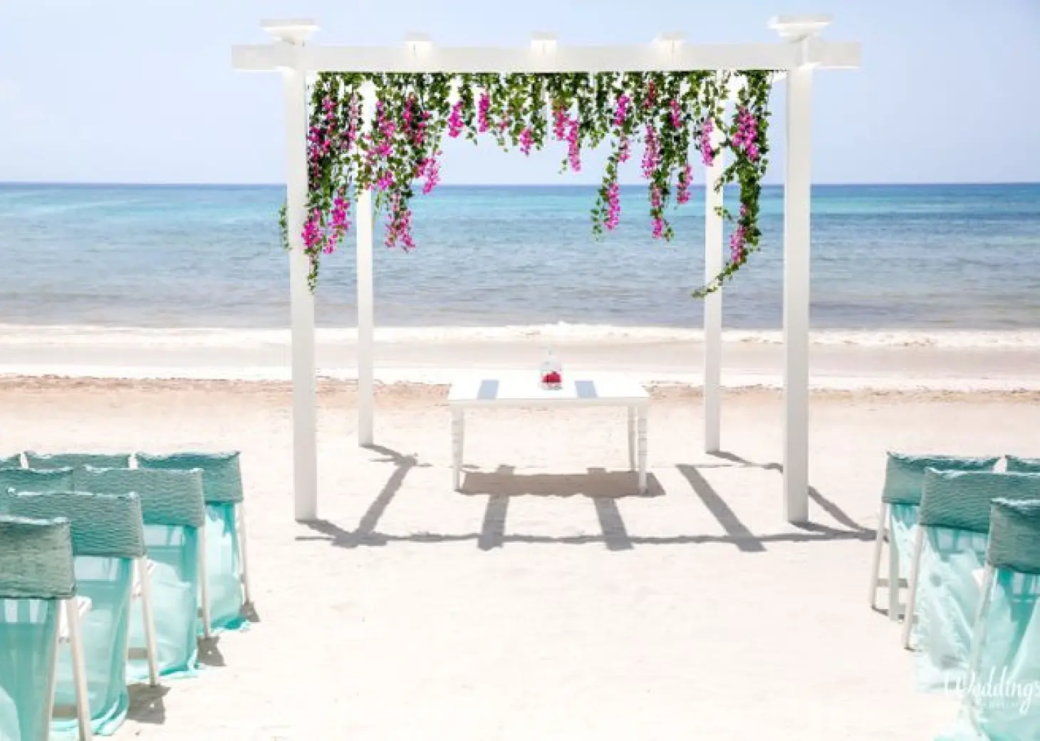 Beachfront wedding ceremony with white pergola and floral decor at Grand Palladium Colonial, Riviera Maya