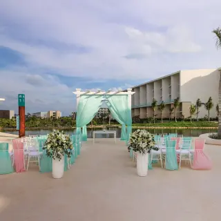 Outdoor wedding ceremony setup with mint green drapery and floral pillars at Grand Palladium Costa Mujeres, Cancun