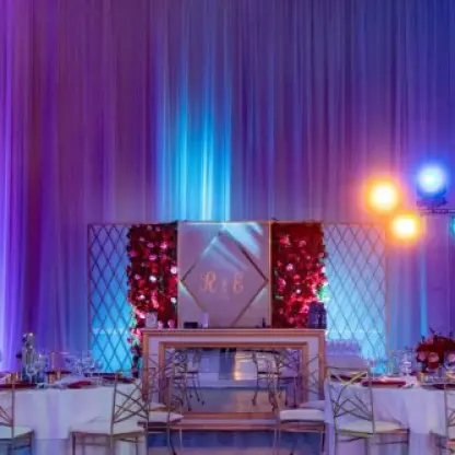 Ballroom wedding reception with purple lighting and floral backdrop at Grand Palladium Costa Mujeres, Cancun