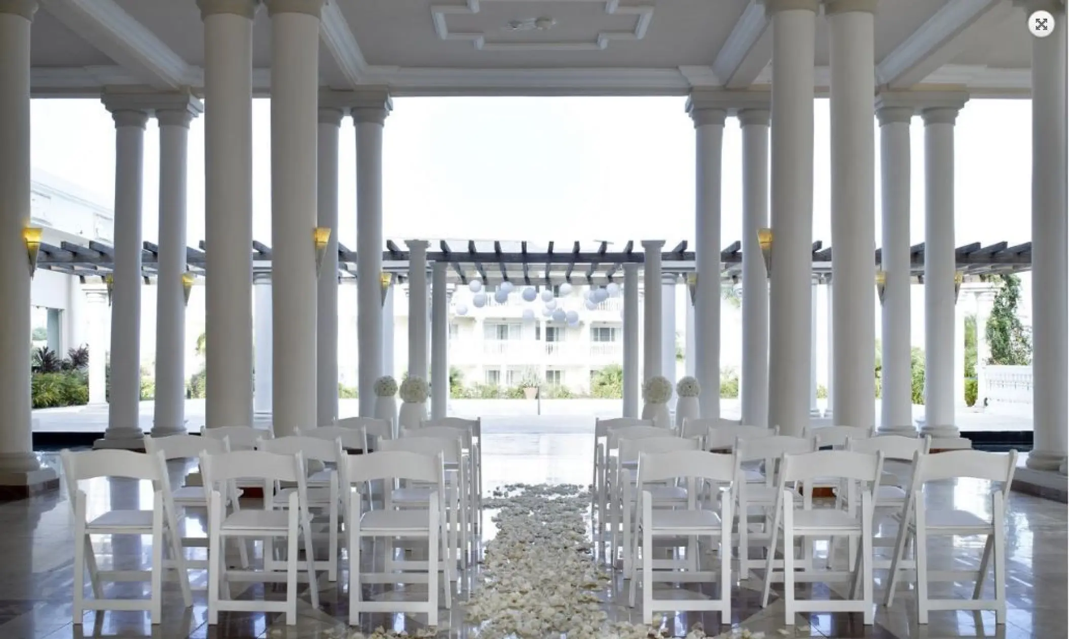 Atrium wedding ceremony setup with white chairs and columns at Grand Palladium Jamaica, Ocho Rios
