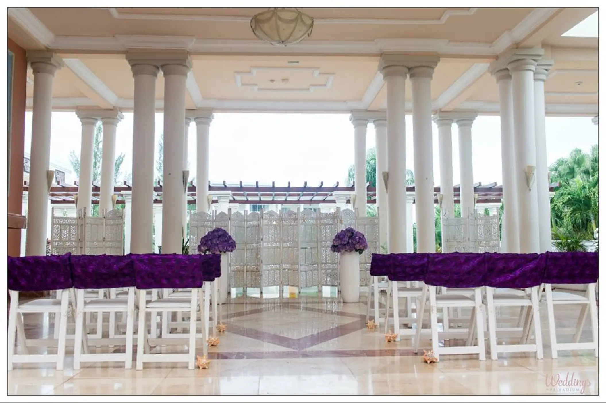 Indoor wedding ceremony setup with purple chairs and white columns at Grand Palladium Jamaica, Ocho Rios