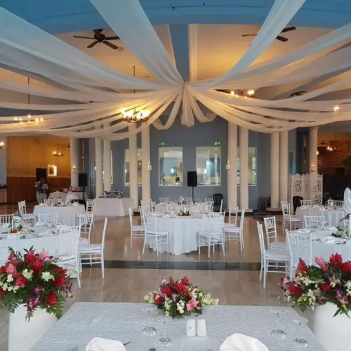 Indoor wedding reception with white ceiling draping and floral centerpieces at Grand Palladium Lady Hamilton, Ocho Rios