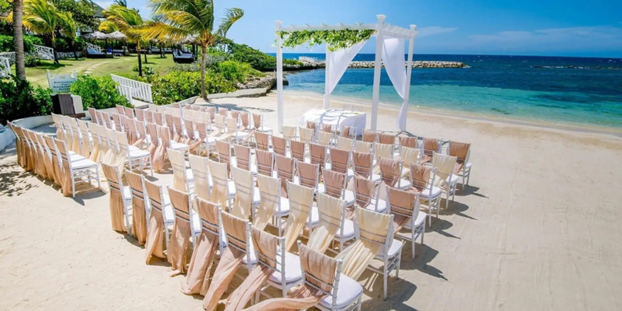 Beachfront wedding ceremony with white gazebo and rows of chairs at Grand Palladium Jamaica, Ocho Rios