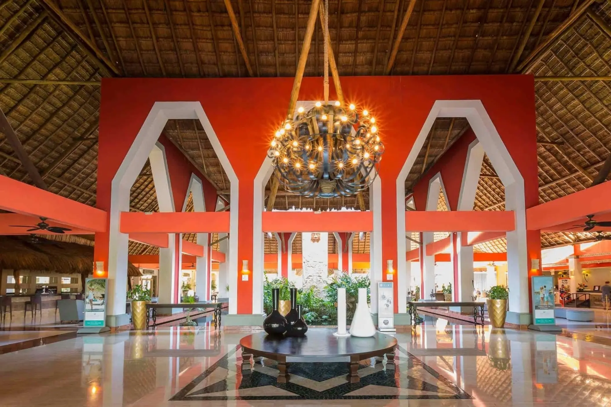 Grand Palladium Kantenah open-air lobby with red pillars and large chandelier, Riviera Maya
