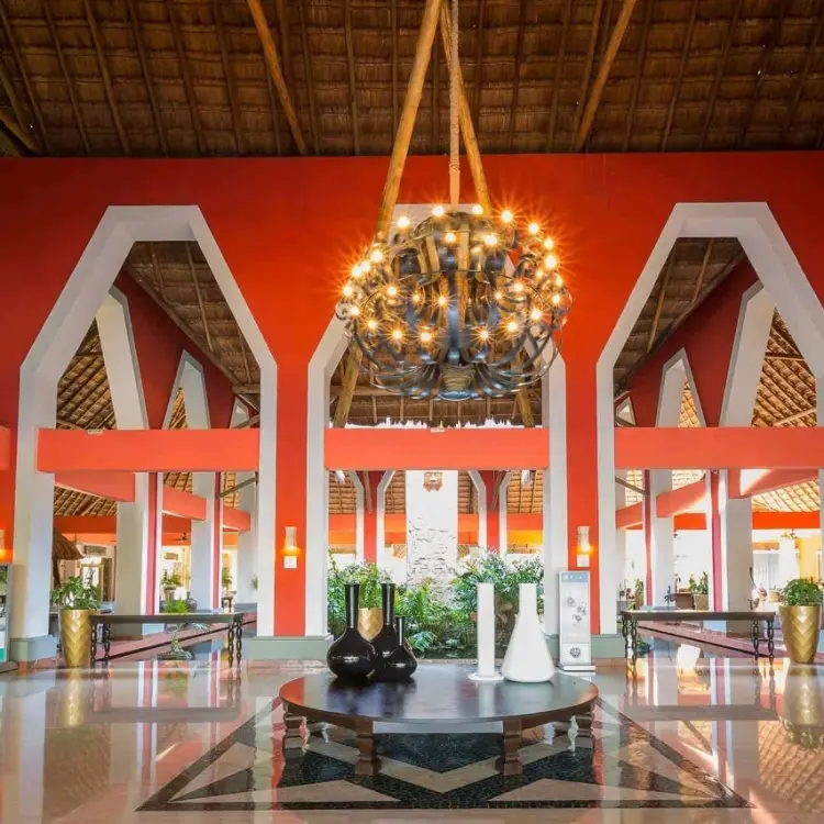 Grand Palladium Kantenah open-air lobby with red pillars and large chandelier, Riviera Maya